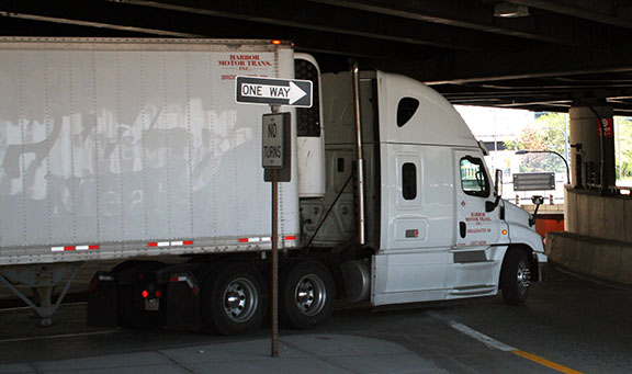 This figure is a photo of a refrigerated semi-trailer being pulled by a tractor unit. The tractor unit includes an integral sleeping compartment directly behind the front seats.